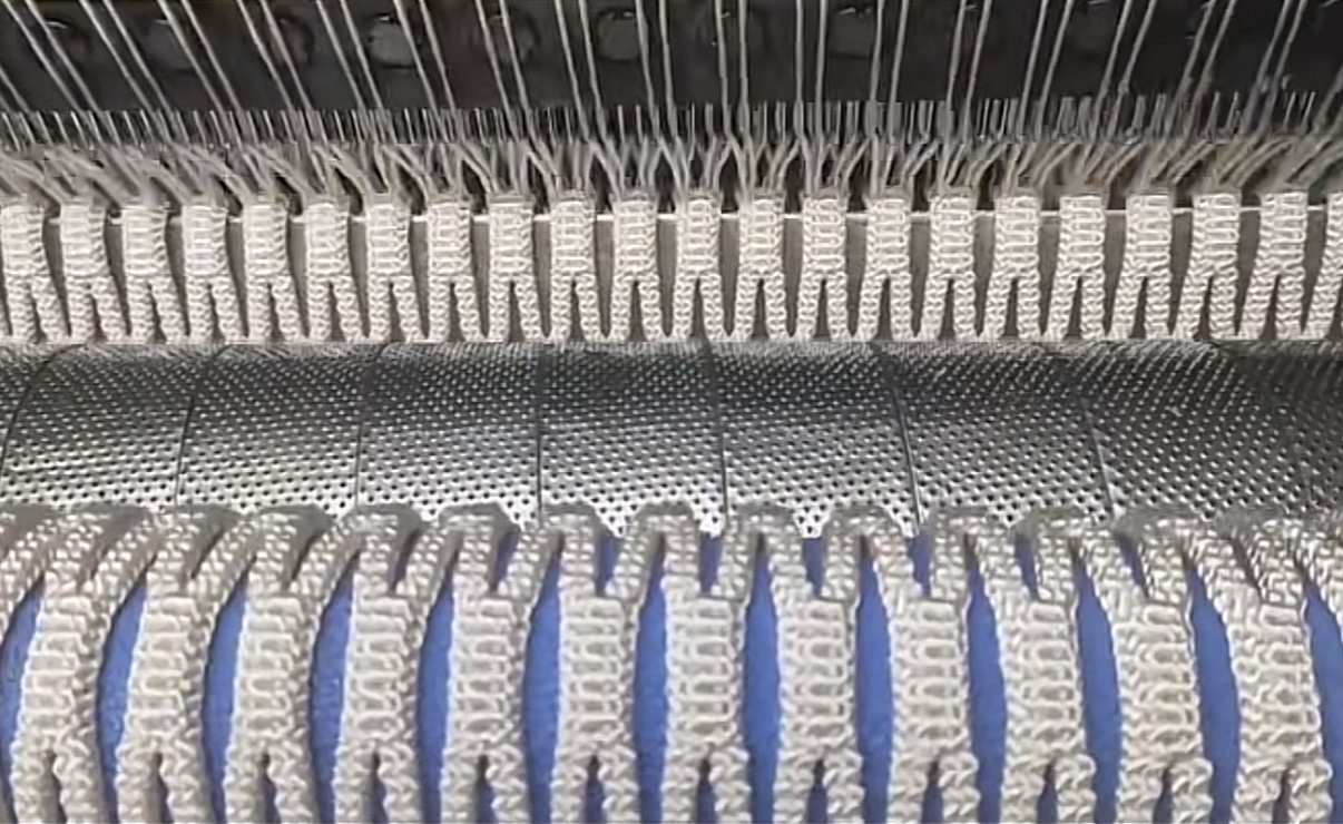 Fishing net warp knitting machine forming mesh during production